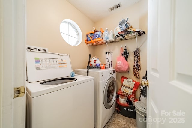 laundry area with light tile patterned floors, a textured ceiling, and independent washer and dryer