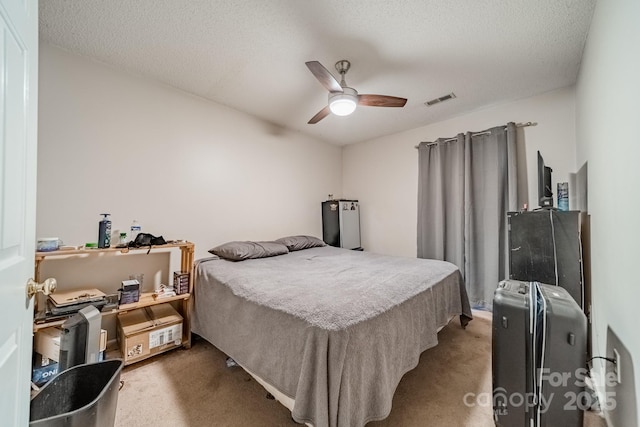 bedroom featuring ceiling fan, a textured ceiling, and carpet flooring