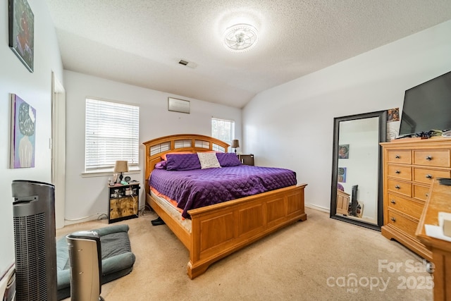 bedroom with lofted ceiling, light colored carpet, and a textured ceiling