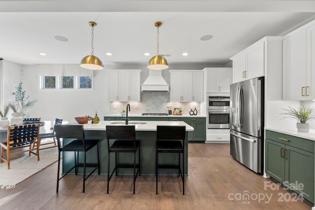 kitchen with dark hardwood / wood-style flooring, custom range hood, stainless steel appliances, sink, and green cabinetry