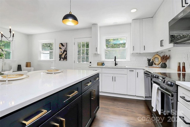 kitchen featuring white cabinets, a healthy amount of sunlight, appliances with stainless steel finishes, and pendant lighting