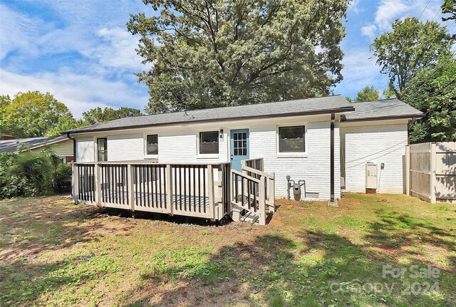 back of house with a lawn and a wooden deck