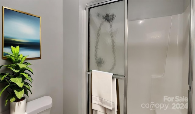 bathroom with toilet and an enclosed shower