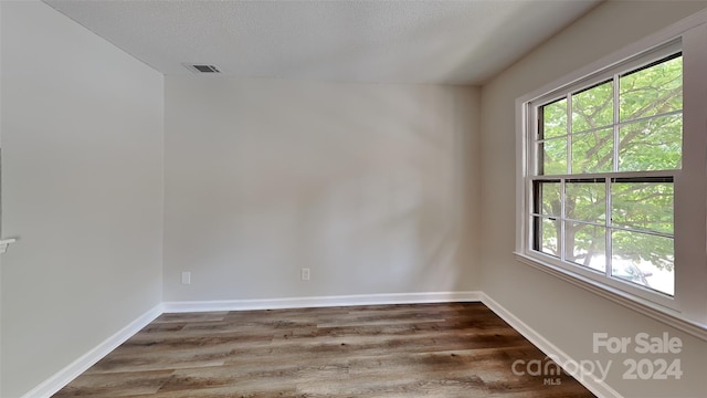 unfurnished room featuring dark hardwood / wood-style floors and a textured ceiling