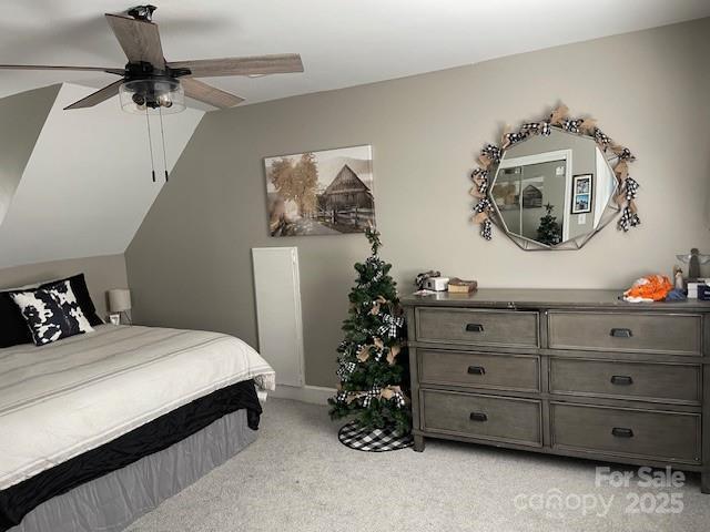 bedroom featuring vaulted ceiling, light carpet, and ceiling fan