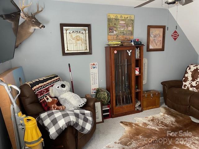 sitting room with ceiling fan and carpet