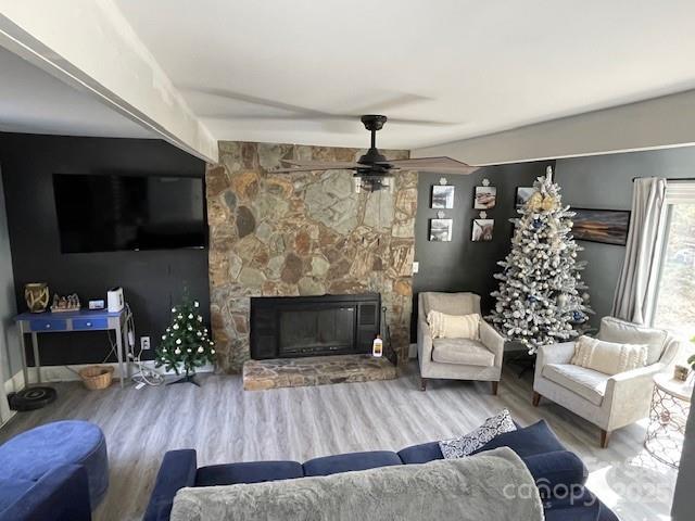 living room with hardwood / wood-style flooring, a fireplace, and ceiling fan