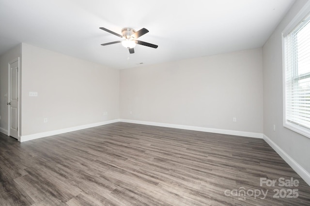 spare room featuring plenty of natural light, ceiling fan, and dark hardwood / wood-style flooring