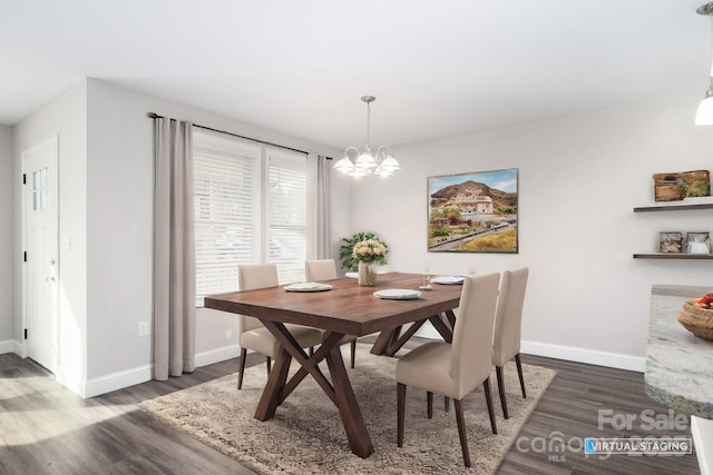 dining area featuring dark wood-type flooring and a chandelier