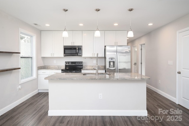 kitchen with white cabinetry, a center island with sink, stainless steel appliances, and decorative light fixtures