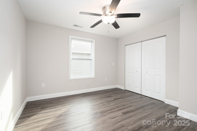 unfurnished bedroom featuring a closet, ceiling fan, and dark wood-type flooring