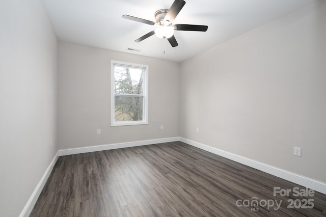 spare room with dark hardwood / wood-style flooring and ceiling fan