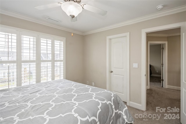 carpeted bedroom with ceiling fan and ornamental molding