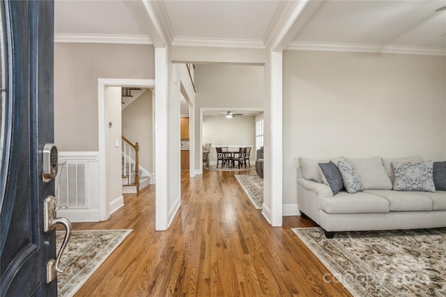 entrance foyer with hardwood / wood-style floors, ceiling fan, and ornamental molding