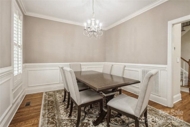 dining area featuring dark hardwood / wood-style floors, ornamental molding, and an inviting chandelier