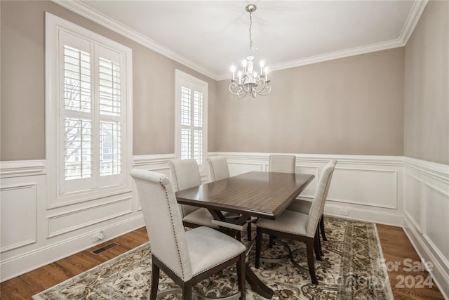 dining space featuring ornamental molding, an inviting chandelier, and dark wood-type flooring