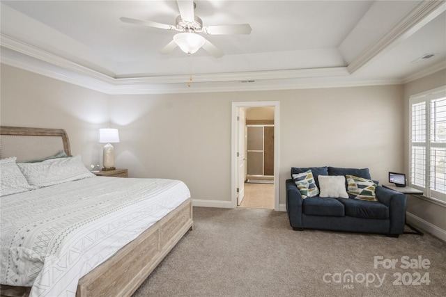 carpeted bedroom featuring a raised ceiling, ensuite bath, ceiling fan, and ornamental molding