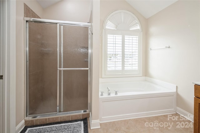 bathroom featuring tile patterned floors, vanity, shower with separate bathtub, and vaulted ceiling