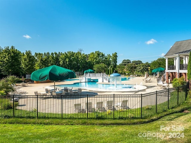 view of pool with pool water feature, a yard, and a patio