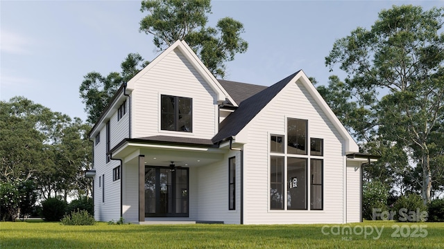 rear view of house featuring a lawn and ceiling fan