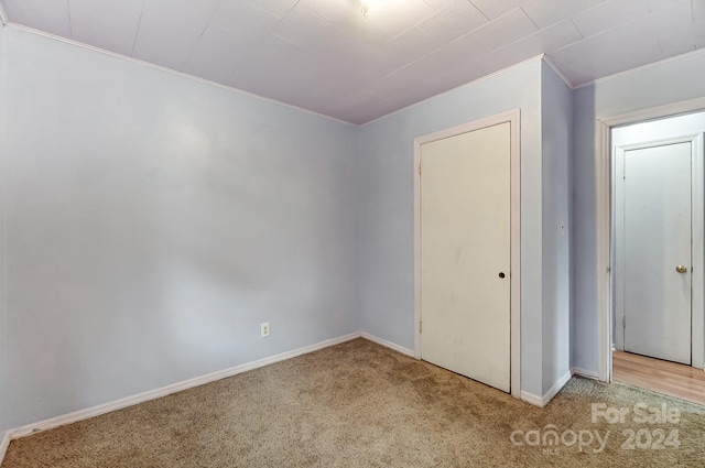 carpeted empty room featuring ornamental molding