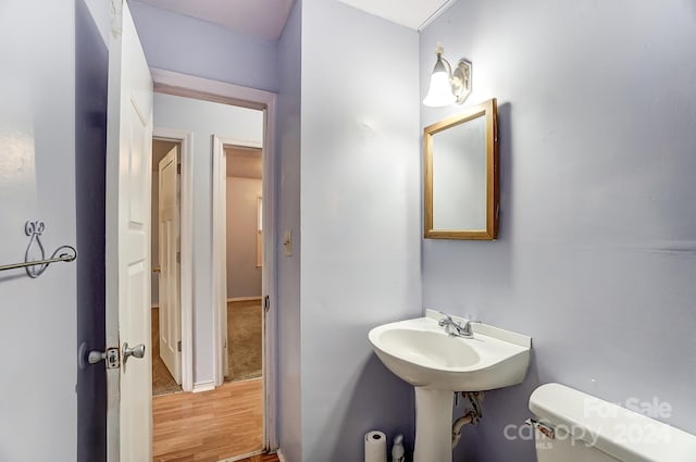 bathroom with hardwood / wood-style floors and toilet