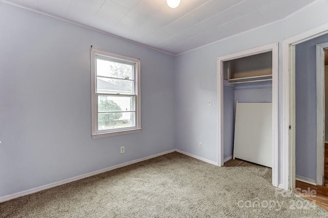 unfurnished bedroom featuring light carpet and a closet