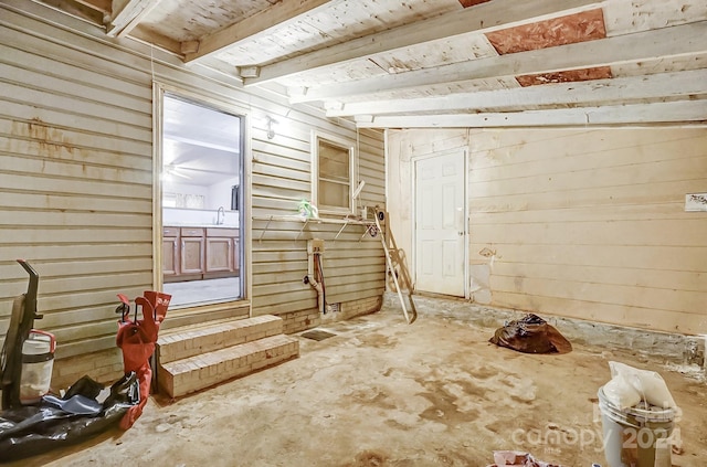 interior space featuring wood walls and concrete floors