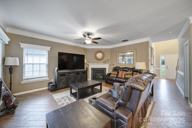 living room featuring hardwood / wood-style floors, ornamental molding, and ceiling fan