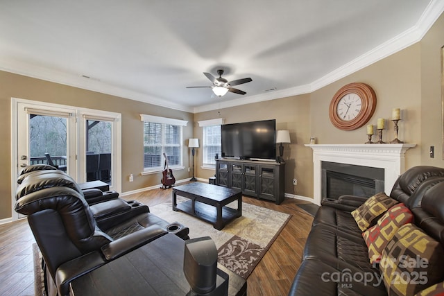 living room featuring ceiling fan, ornamental molding, and wood-type flooring