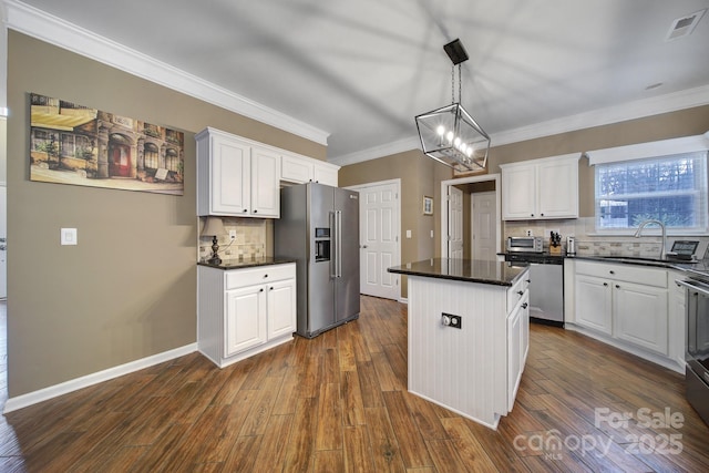 kitchen with a kitchen island, white cabinets, and appliances with stainless steel finishes