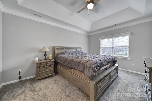 bedroom with ornamental molding, light carpet, ceiling fan, and a tray ceiling