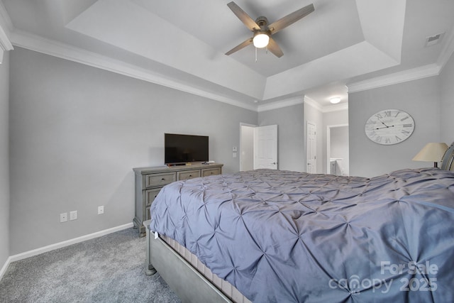 carpeted bedroom featuring crown molding, connected bathroom, ceiling fan, and a tray ceiling