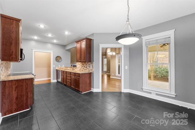 kitchen featuring dishwasher, tasteful backsplash, a sink, and baseboards