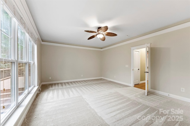 unfurnished room with light carpet, baseboards, ornamental molding, and a ceiling fan