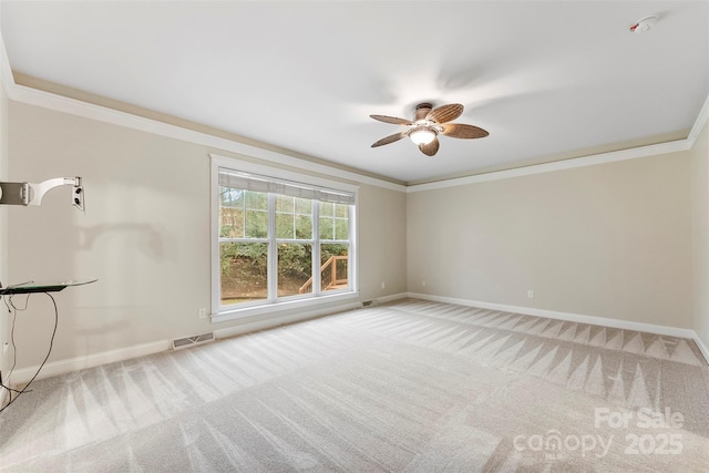 empty room featuring baseboards, visible vents, crown molding, and carpet flooring