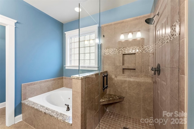 full bath featuring a shower stall, baseboards, and a bath