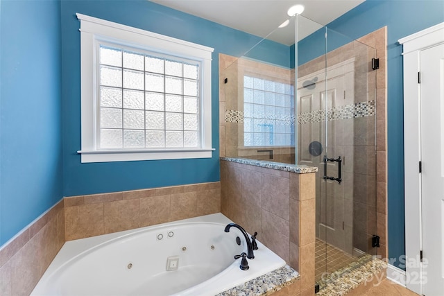 bathroom featuring a stall shower, plenty of natural light, and a tub with jets