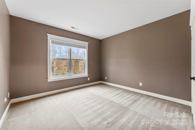 carpeted spare room with baseboards and visible vents