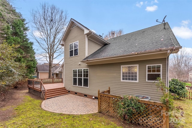 back of property featuring a wooden deck, a lawn, and a patio