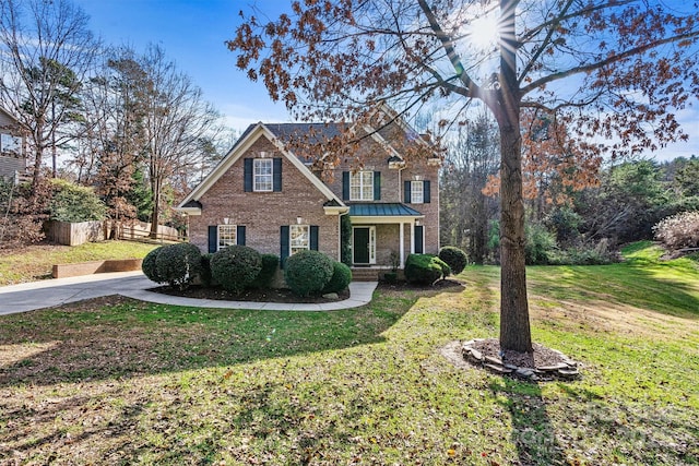 view of property featuring covered porch and a front yard