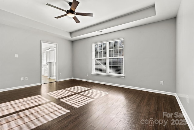 spare room featuring ceiling fan, hardwood / wood-style flooring, and a tray ceiling