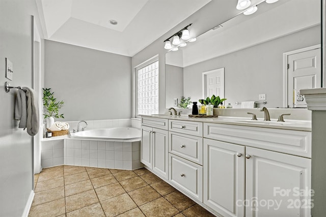 bathroom with tiled tub, tile patterned floors, vanity, and a raised ceiling