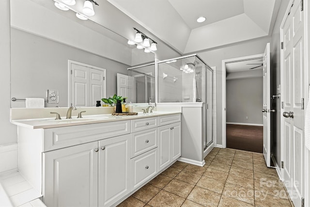 bathroom featuring tile patterned flooring, a raised ceiling, an enclosed shower, and vanity