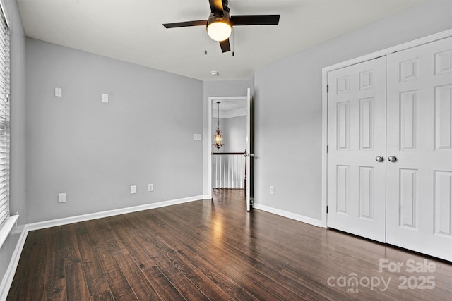 unfurnished bedroom with ceiling fan, dark hardwood / wood-style floors, and a closet