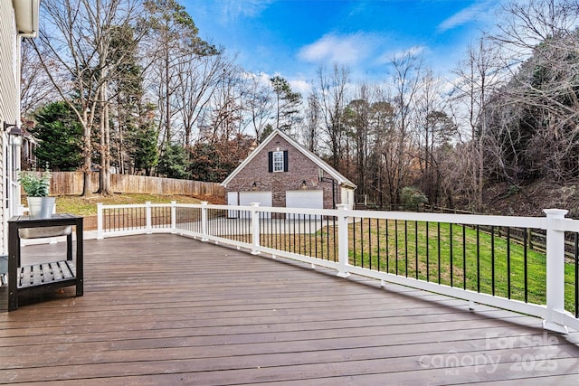 deck with a garage, a lawn, and an outdoor structure