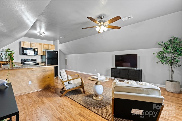 living room featuring ceiling fan, light hardwood / wood-style flooring, and vaulted ceiling