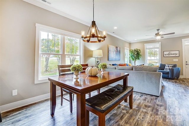 dining space with ceiling fan with notable chandelier, dark hardwood / wood-style flooring, and crown molding