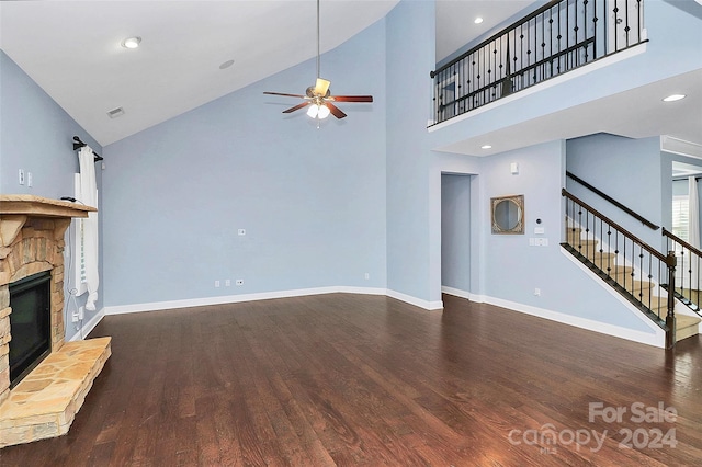 unfurnished living room with dark hardwood / wood-style floors, ceiling fan, a fireplace, and high vaulted ceiling