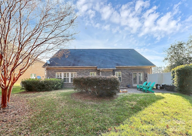 rear view of house with a yard and a patio